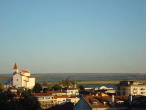 uma cidade com edifícios e uma igreja e água em 1Bed Tagus River View em Alhandra