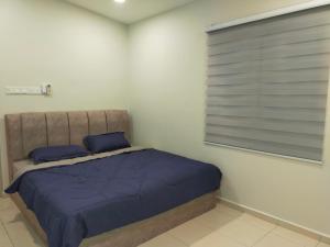 a bedroom with a bed with blue sheets and a window at My 23 Homestay in Muar