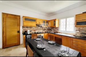 a kitchen with wooden cabinets and a black counter top at Villa oussoua in Taguermess
