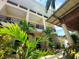 un bâtiment avec des plantes devant lui dans l'établissement TLShaw Homestay, à General Luna