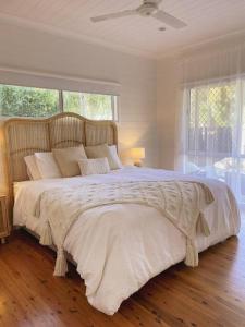a bedroom with a large bed with a large window at Port Douglas Beach Cottage in Port Douglas