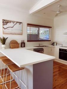 a kitchen with a white counter top in a room at Port Douglas Beach Cottage in Port Douglas