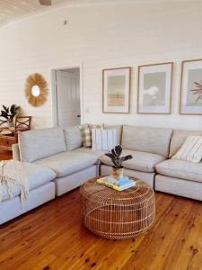 a living room with a couch and a table at Port Douglas Beach Cottage in Port Douglas