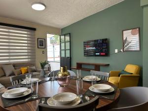 une salle à manger avec une table et un canapé dans l'établissement Xochimilco Apartment, à Oaxaca
