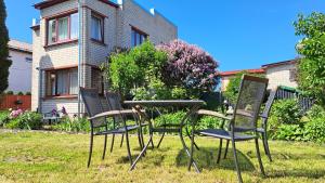 dos sillas y una mesa frente a una casa en Liepājas brīvdienu māja ar dārzu en Liepāja