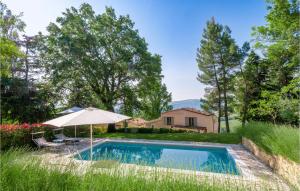 a swimming pool with an umbrella and a house at Amazing Home In Mergo With House A Panoramic View in Mergo