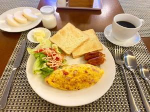 um prato de comida com uma omelete e torradas e café em Marigold Hotel Hanoi em Hanói