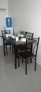 einen Tisch und Stühle mit Teller und Schüsseln darauf in der Unterkunft Simple and elegant 1 bed condo in Cebu city in Cebu City