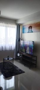 sala de estar con TV de pantalla plana y mesa en Simple and elegant 1 bed condo in Cebu city, en Cebú