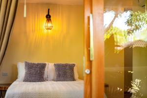 een slaapkamer met een bed, een lamp en een raam bij Portales del Tayrona Garden Hotel in Calabazo