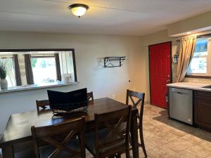 a kitchen with a table and chairs and a red door at All Star Inn & Suites in Wisconsin Dells