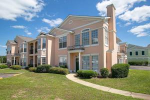 a large house with a lawn in front of it at Quiet, Spacious Condo with 2 AWESOME pools and close to the beach in Gulfport