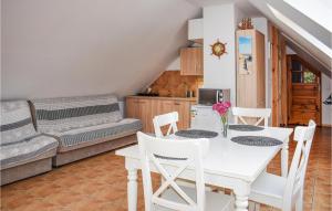 a kitchen and dining room with a white table and chairs at 1 Bedroom Amazing Apartment In Rydzewo in Rydzewo