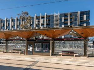 堪培拉Midnight Luxe 1BR 1Bath Apartment 104 in the heart of Braddon Pool Sauna Secure Parking Wine WiFi的建筑物前有长椅