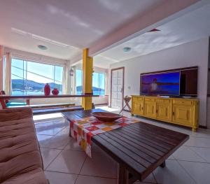sala de estar con mesa y TV en Espetacular! Casa de Praia em Arraial do Cabo, en Arraial do Cabo