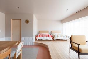 two beds in a room with a table and chairs at ROOM design hotel in Nanao