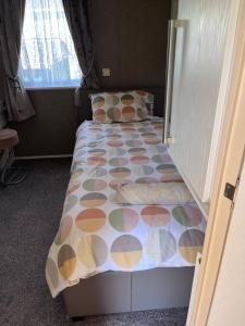 sypialnia z łóżkiem z kolorową narzutą w obiekcie Meridian Lodge w mieście Great Billing