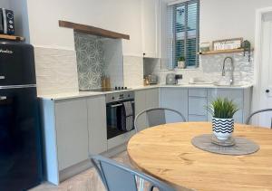 a kitchen with a wooden table and a dining room at ‘Sandy Bottom’ - Apartment by the sea in Combe Martin