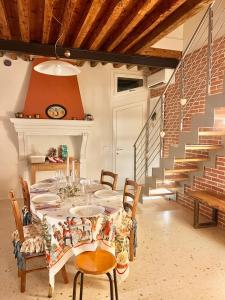 uma sala de jantar com mesa, cadeiras e escadas em Boutique House Alle Loggie Palladiane di Villa Contarini em Piazzola sul Brenta