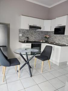 a kitchen with a table and chairs in a kitchen at 19 Mirabelle Place in Pietermaritzburg