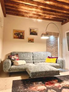 una sala de estar con un sofá gris en una habitación en Boutique House Alle Loggie Palladiane di Villa Contarini, en Piazzola sul Brenta