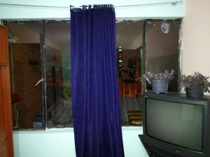 a blue curtain in front of a television at Casa 2600 in Bogotá