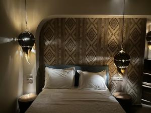 ein Schlafzimmer mit einem Bett mit zwei Lampen und zwei Kissen in der Unterkunft The Cactus Project in Loutraki