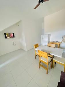 uma sala de jantar com uma mesa branca e cadeiras em Casa do Bruno - Apartamento terreo - 1 - Terra - Quarto e sala com cozinha americana na praia do preá-CE em Praia do Preá