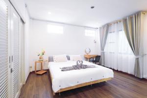 a bedroom with a white bed with a large window at Ratchada Retreat Boutique Villa 1 in Bangkok +48 photos