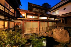 un edificio con finestre e una persona in piedi all'esterno di Yudanaka Seifuso a Yamanouchi