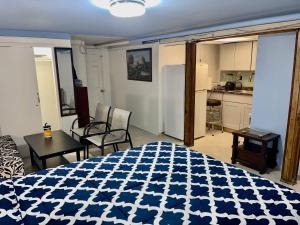 a bedroom with a blue and white bed and a kitchen at LGA Airport near, Studio walk in bsmt Apt in a Private House! in East Elmhurst