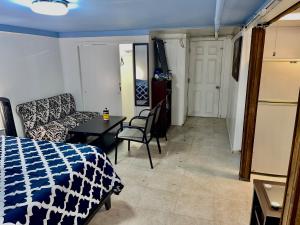 a room with a bed and a table and a couch at LGA Airport near, Studio walk in bsmt Apt in a Private House! in East Elmhurst