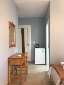 Cette chambre dispose d'une table en bois et d'une cuisine. dans l'établissement Tasos Rooms, à Prinos