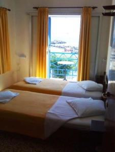 2 camas en una habitación de hotel con ventana en Kythereia Hotel en Agia Pelagia - Citera