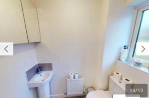 a white bathroom with a sink and a toilet at Dengenzy House in Seacroft