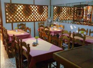a restaurant with tables and chairs with pink table cloth at Kythereia Hotel in Agia Pelagia