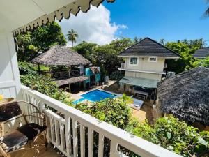 uma vista para a piscina a partir da varanda de uma casa em Ebb & Flow em Paje