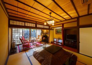 a room with a bed and a living room at Kannomori in Yufu