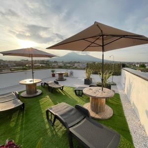 a patio with tables and umbrellas on a roof at B&b Pompei Window in Pompei
