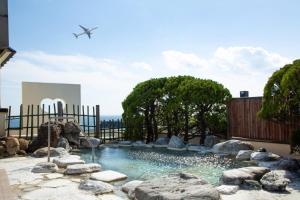 函館的住宿－啄木地酒店，一个带岩石和围栏的游泳池