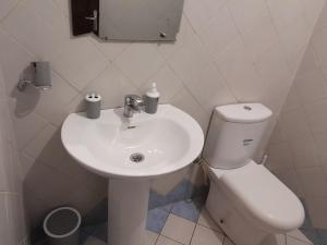 bagno bianco con lavandino e servizi igienici di Lydie's Home a Yaoundé