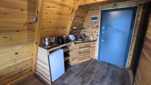 una cocina en una cabaña de madera con una puerta azul en Tutaste Bungalov, en Arhavi
