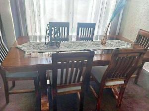 a wooden dining room table with four chairs around it at Tu Casa "Corazon de Cordillera" in Angol