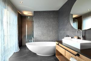 a bathroom with a large white tub and a sink at Romantikhotel Zell am See in Zell am See +27 photos