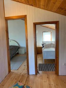 um quarto com duas portas e um quarto com uma cama em Kaszuby Dom nad jeziorem em Suleczyno