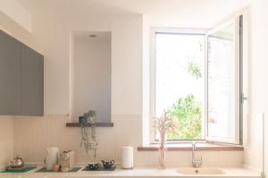 uma cozinha com um lavatório e uma janela em Urbino Experience em Urbino