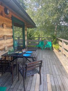 a wooden deck with a table and chairs on it at Chata w Szczyrku in Szczyrk