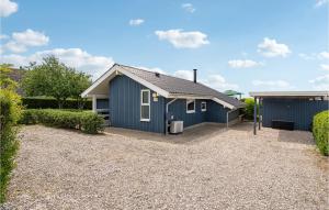 a blue house with a gravel driveway at Amazing Home In Assens With 3 Bedrooms And Wifi in Assens