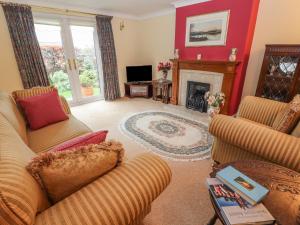 a living room with two couches and a fireplace at Bryn Offa cottage in Holywell
