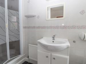 een witte badkamer met een wastafel en een douche bij Bryn Offa cottage in Holywell +28 foto's